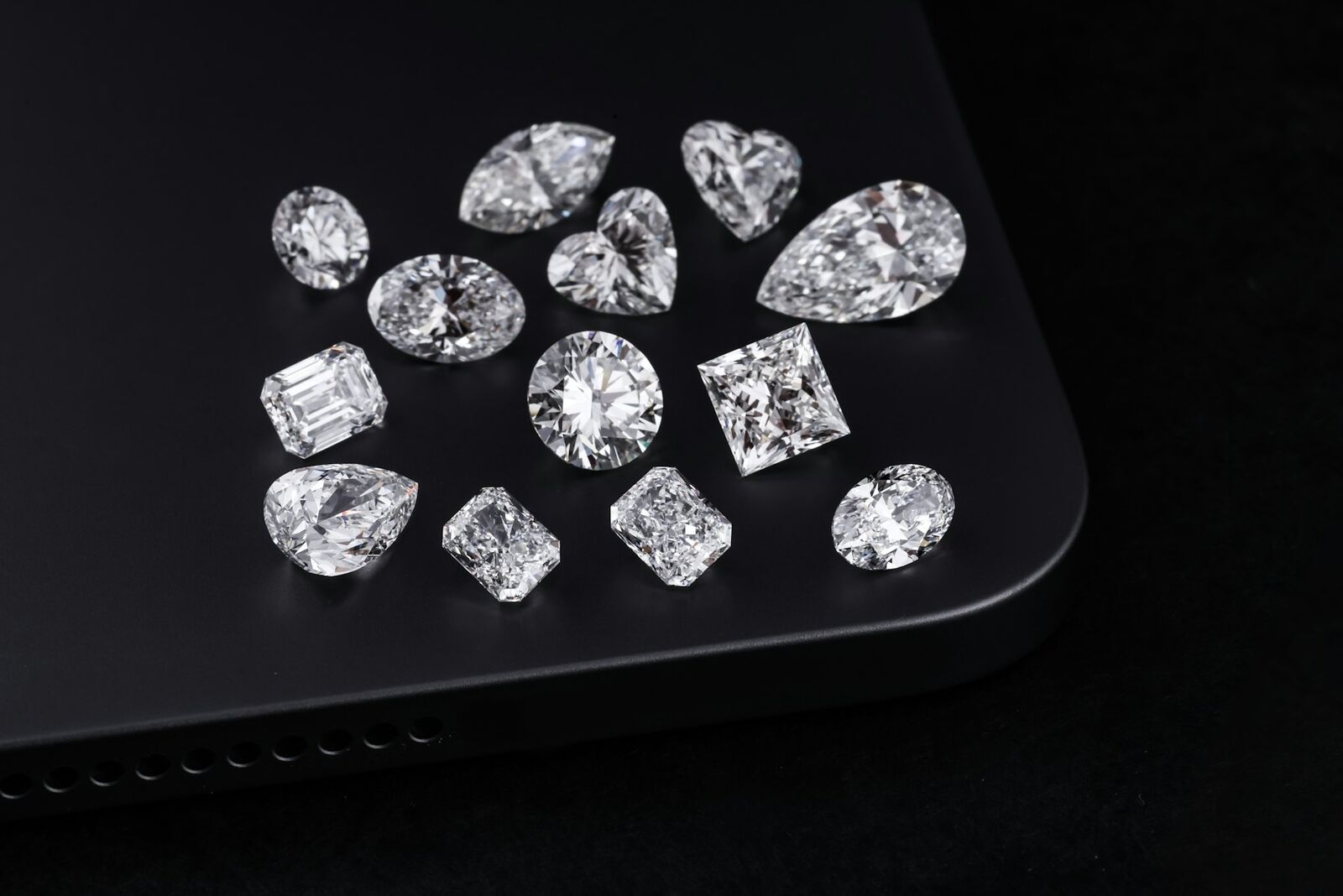 Loose diamonds in many shapes scattered on black